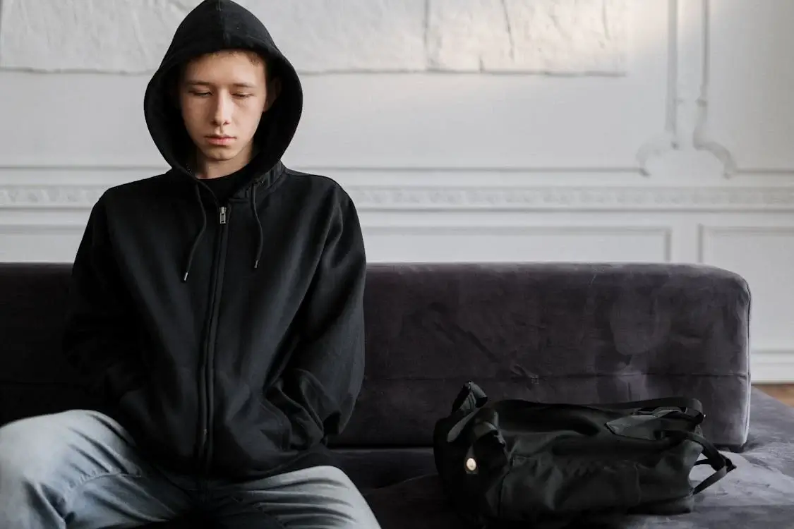 sad teen sitting on couch