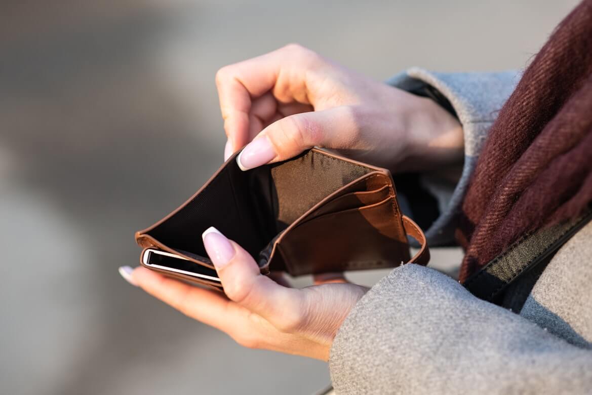A picture of manicured hands holding open an empty wallet